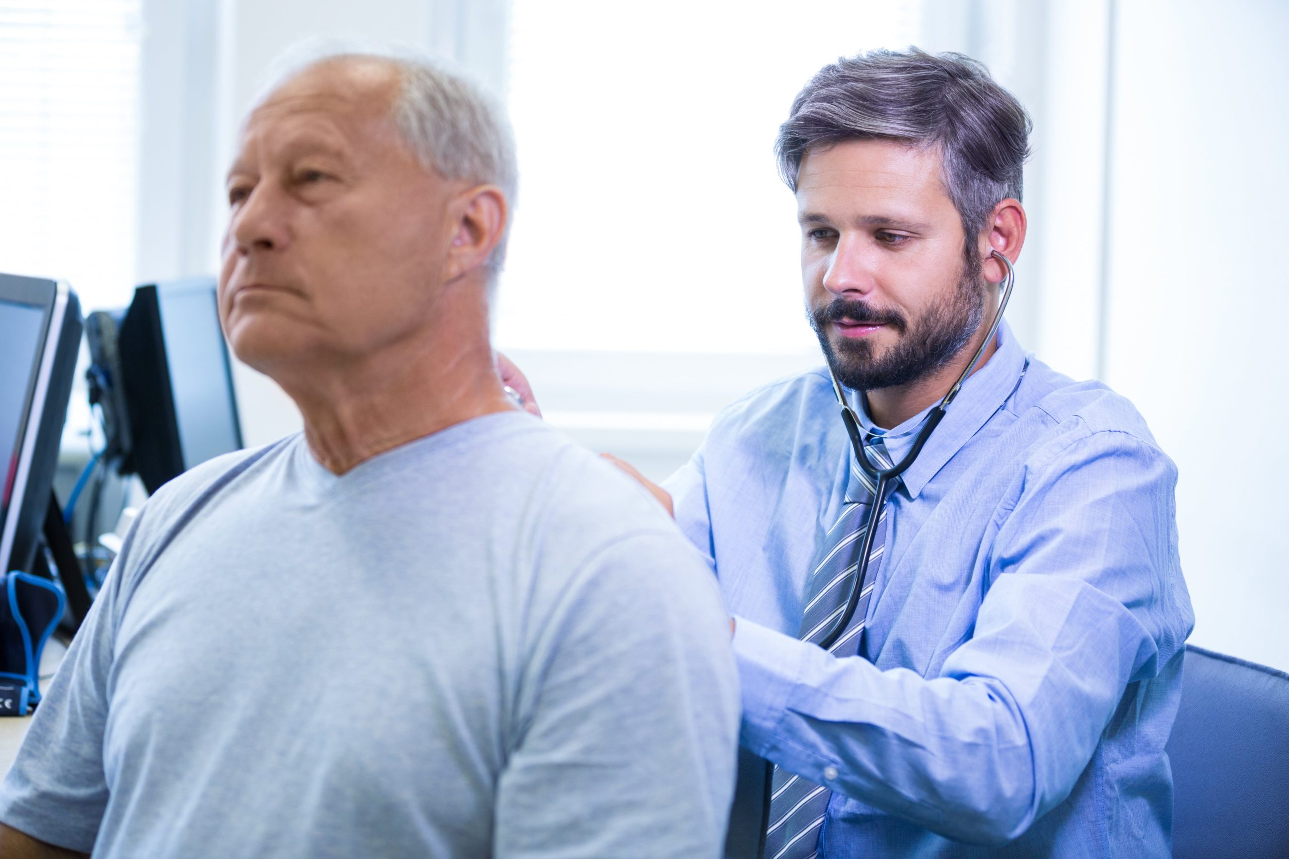 Médico especialista explica a um paciente quando a cirurgia de coluna é indicada e as opções minimamente invasivas disponíveis.